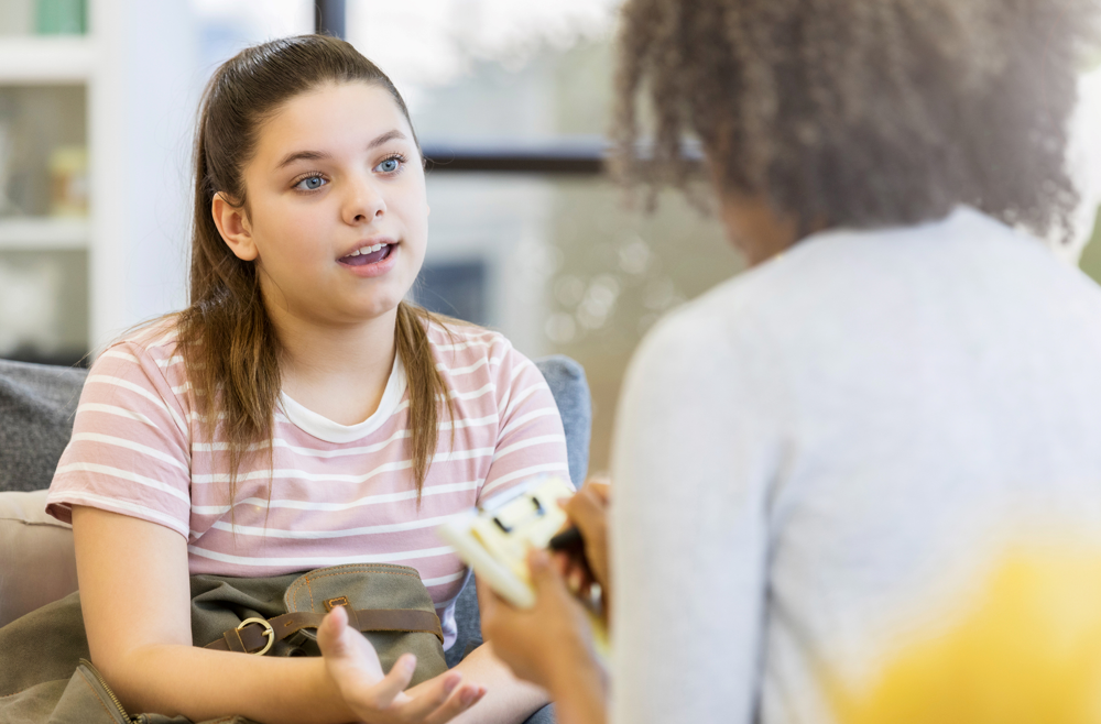 A teenage girl speaking with a counselor